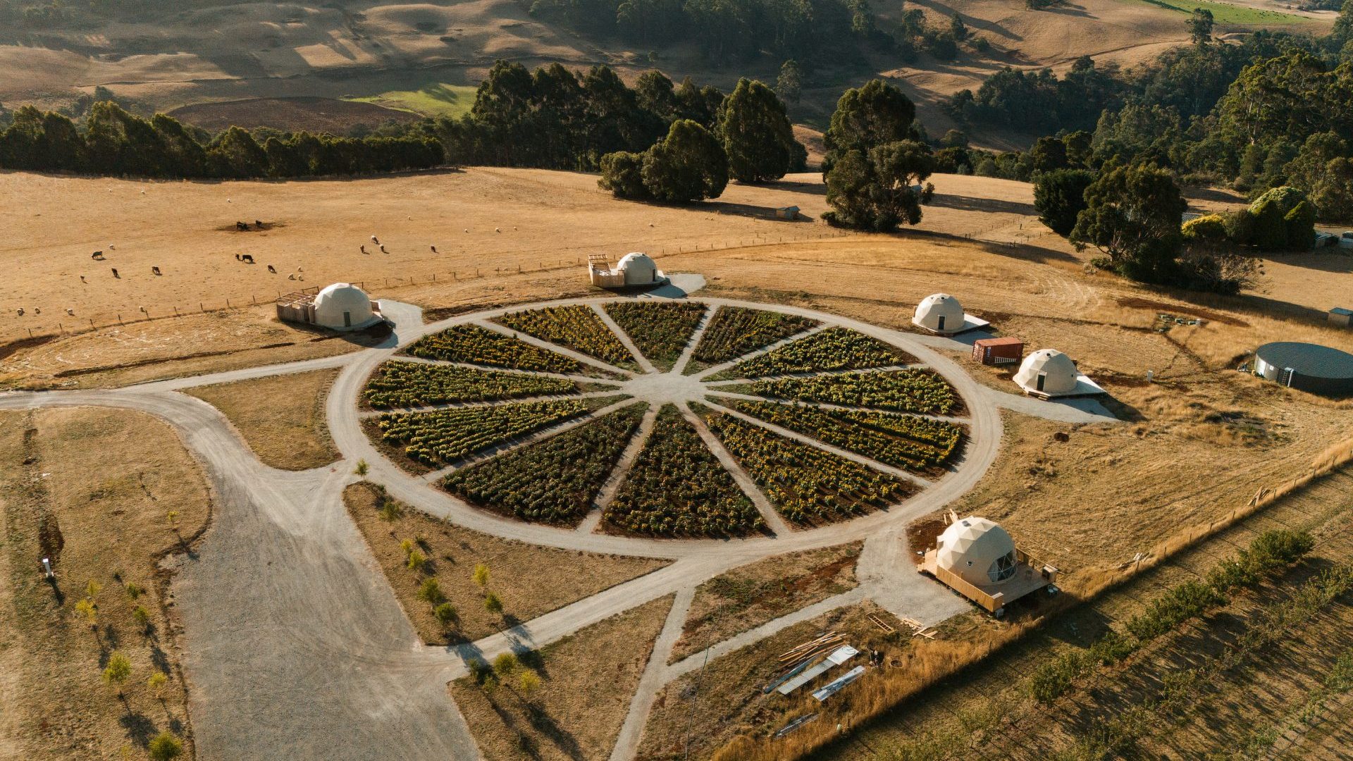 An aerial view of glamping dome tents around a circular kitchen garden