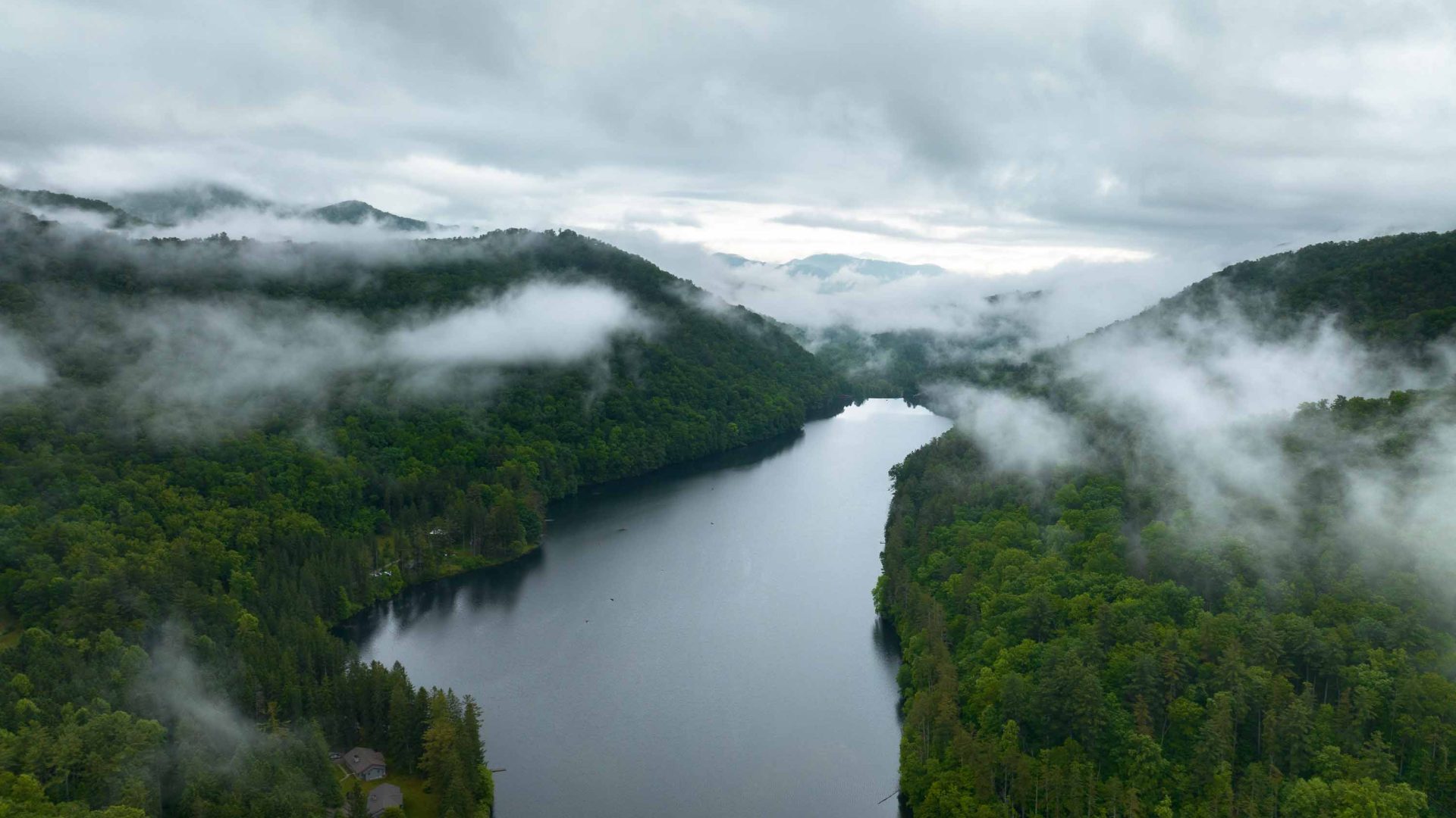 Mist rises above the mountains and river