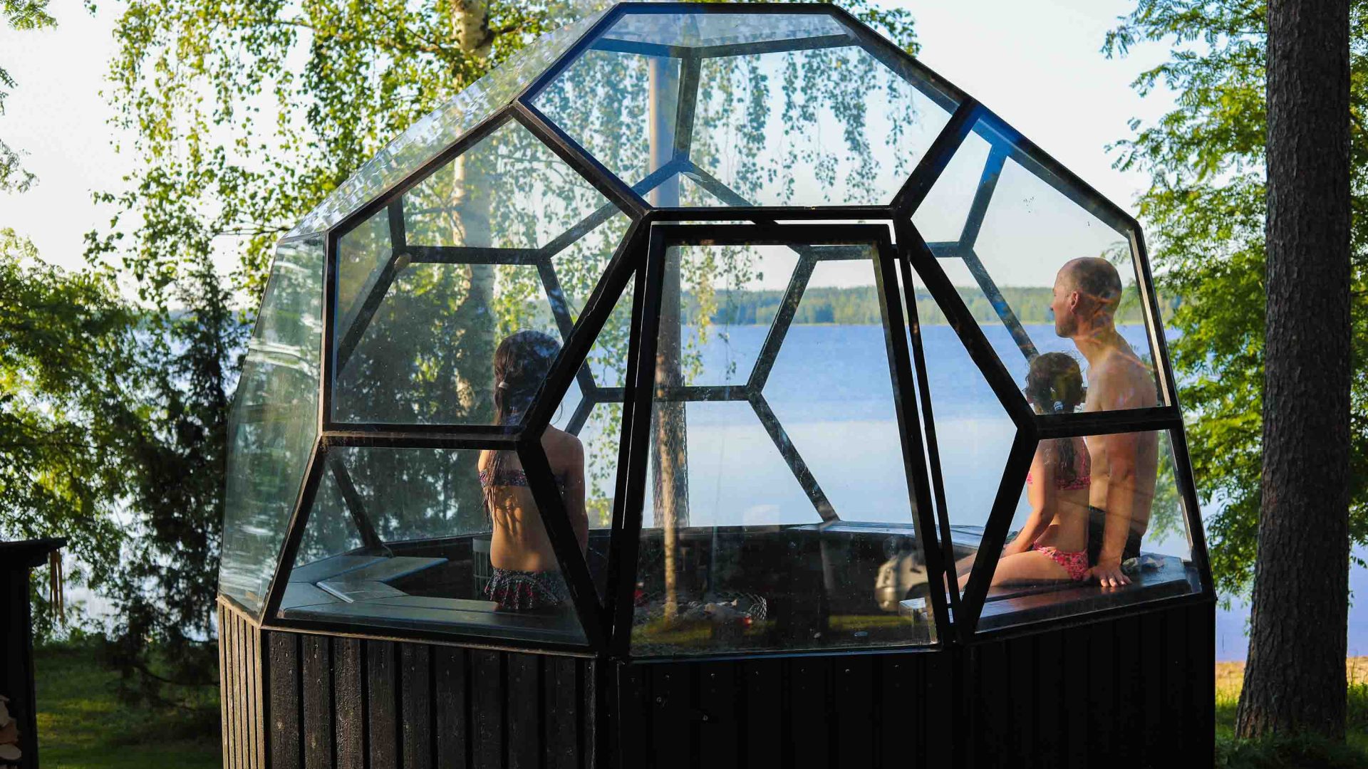 A man and his two children sit in a sauna.