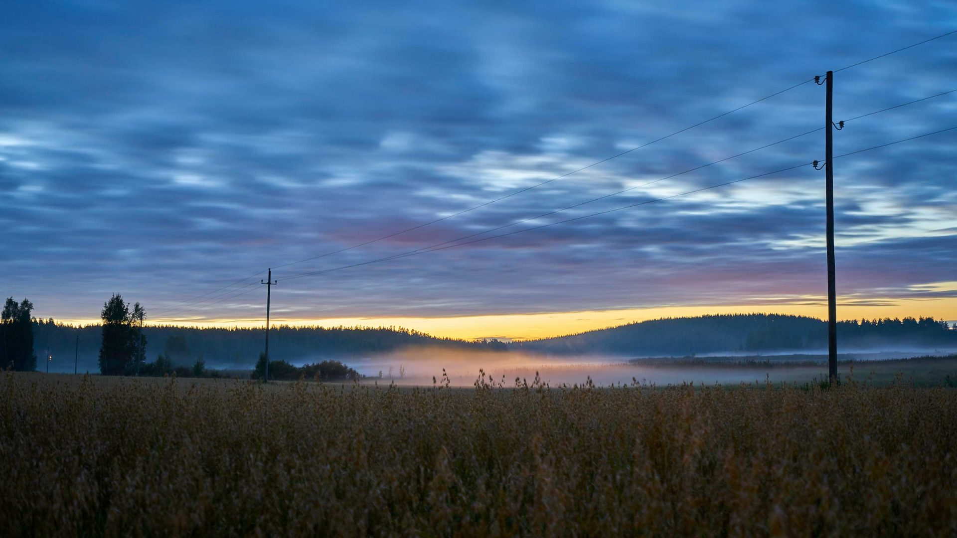 A sunset over fields and water.