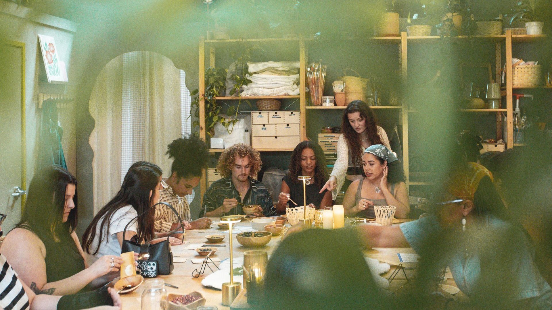 Group of people sit communally at a crafting table