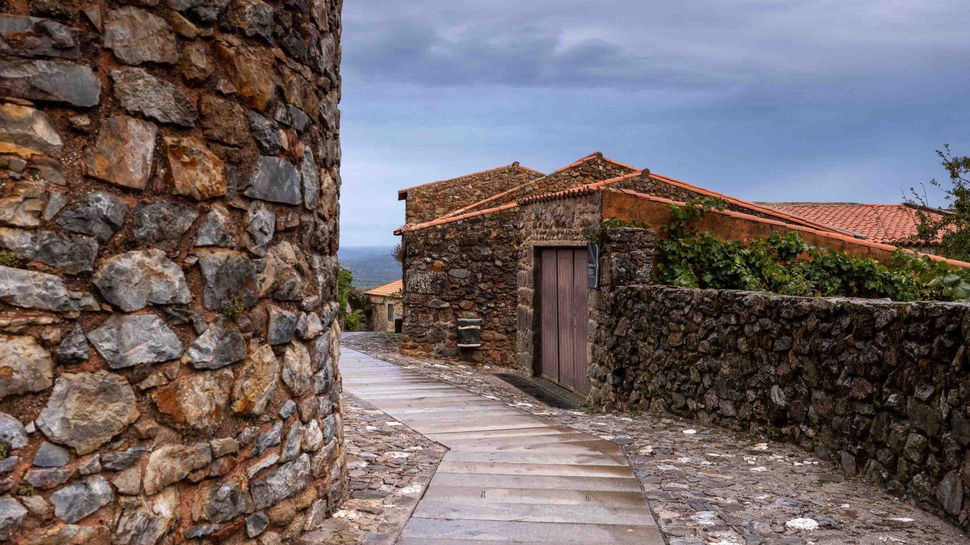 A bobbled street runs past stone houses.