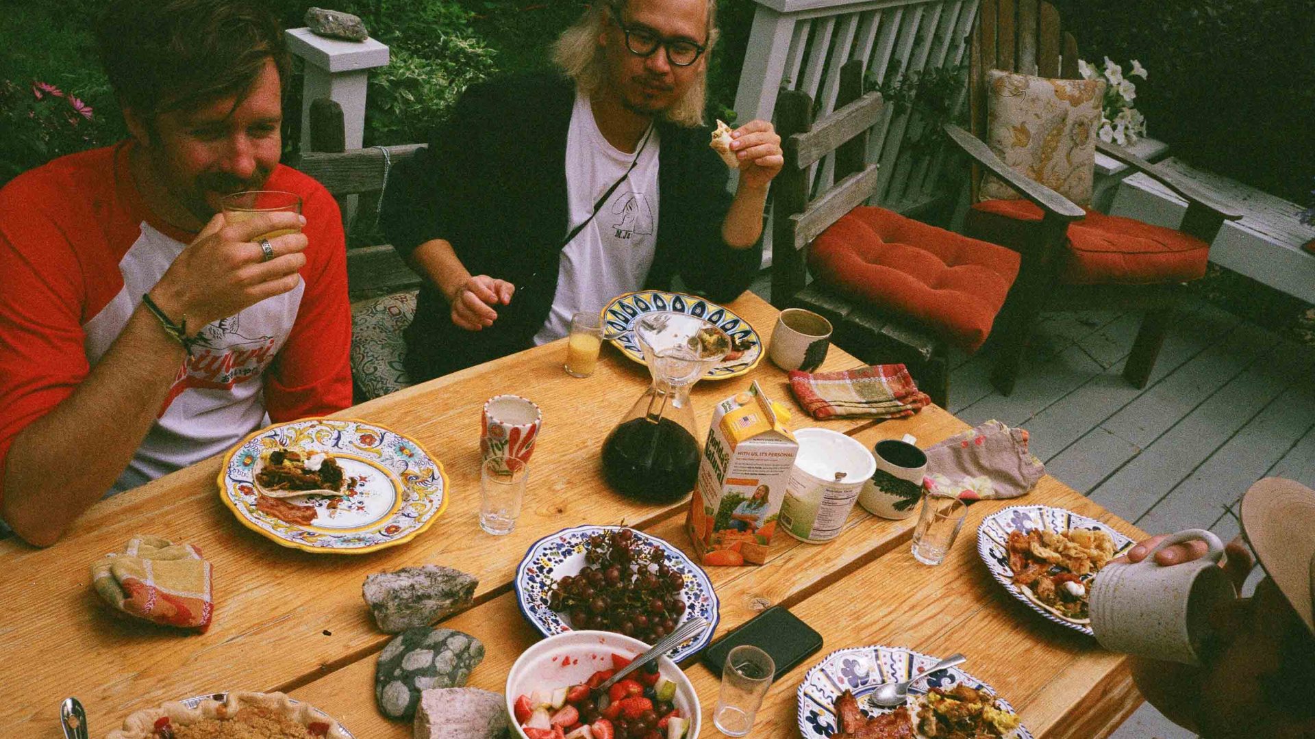 Friends enjoy a meal at an outdoors table.