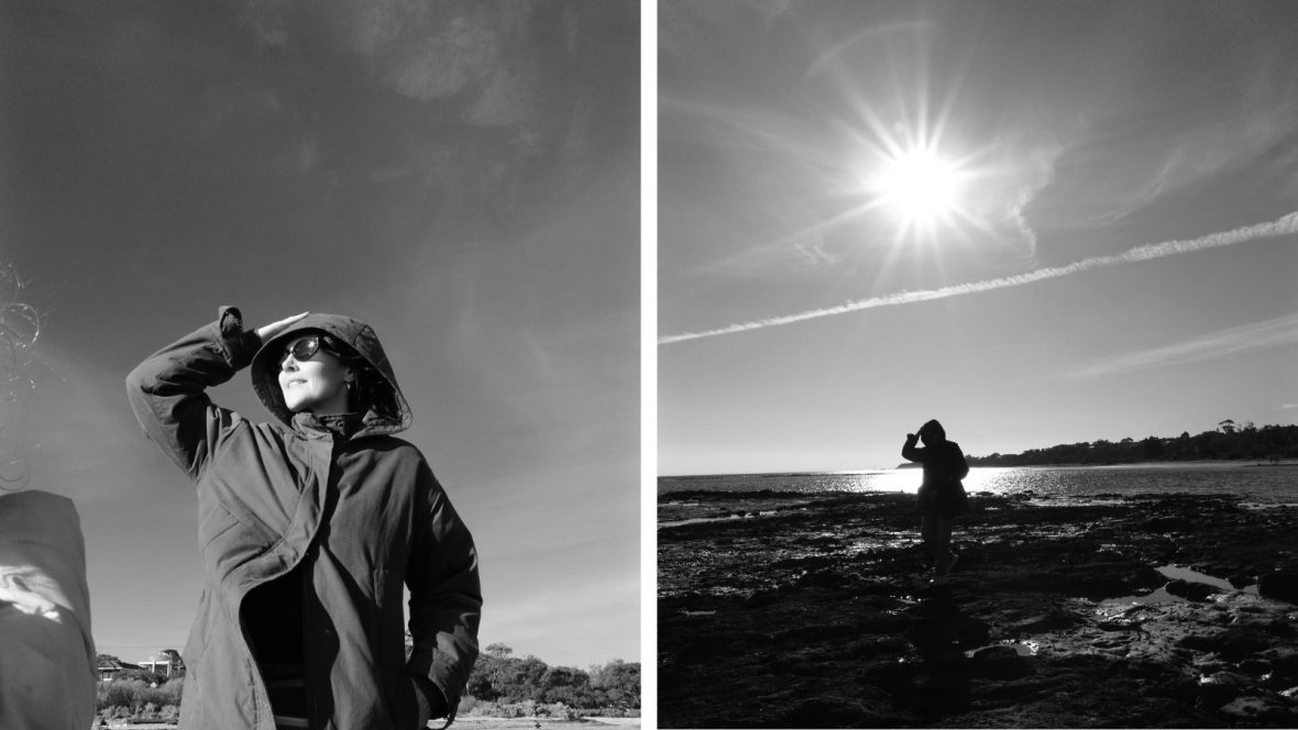 A woman on a beach in black and white.