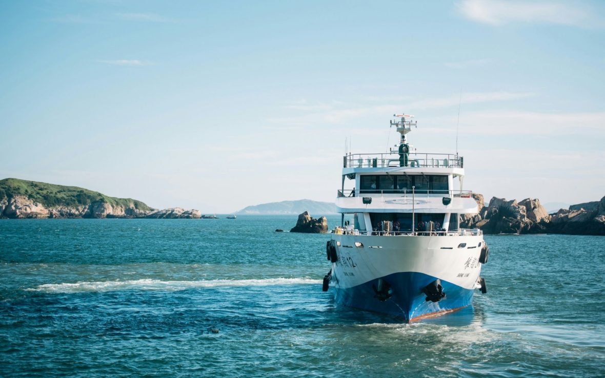 View of an oncoming ferry with a blue hull.